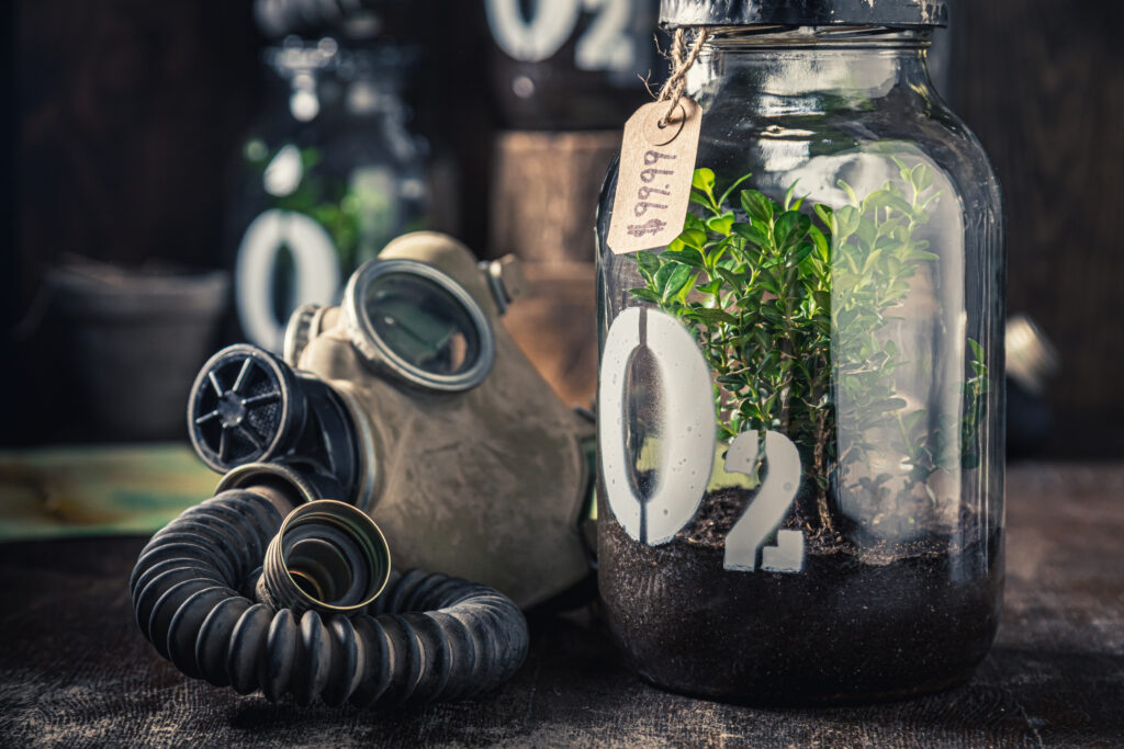 An oxygen mask and a piece of plant in the jar serve as a symbol of climate change